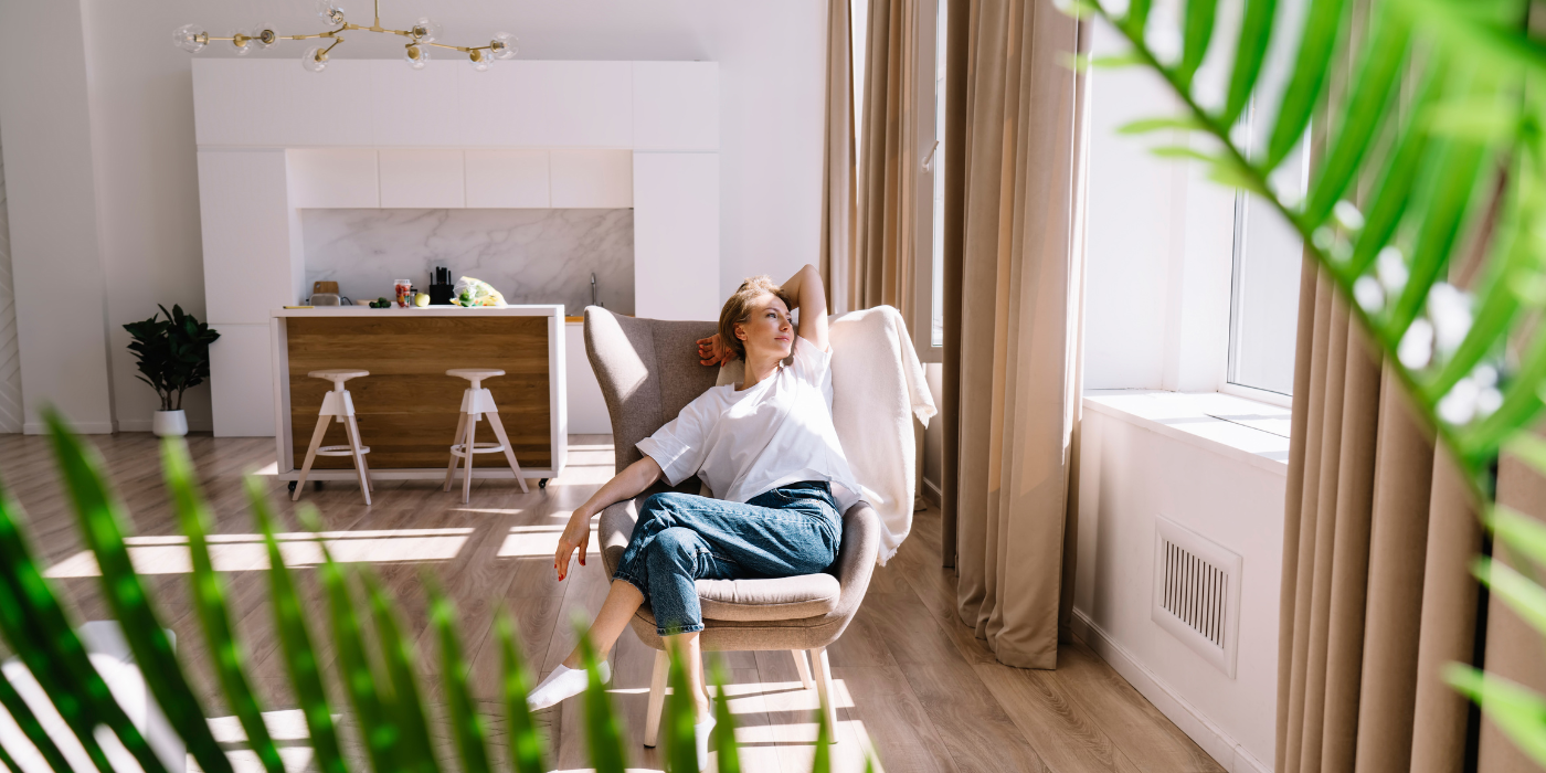 Benefits of Regular House Cleaning Services Content Woman Resting on Chair in Light Room