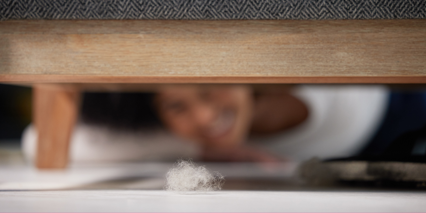 How to Clean Hard-to-Reach Places in Your Home shot-of-an-unrecognizable-woman-finding-a-ball-of-fur