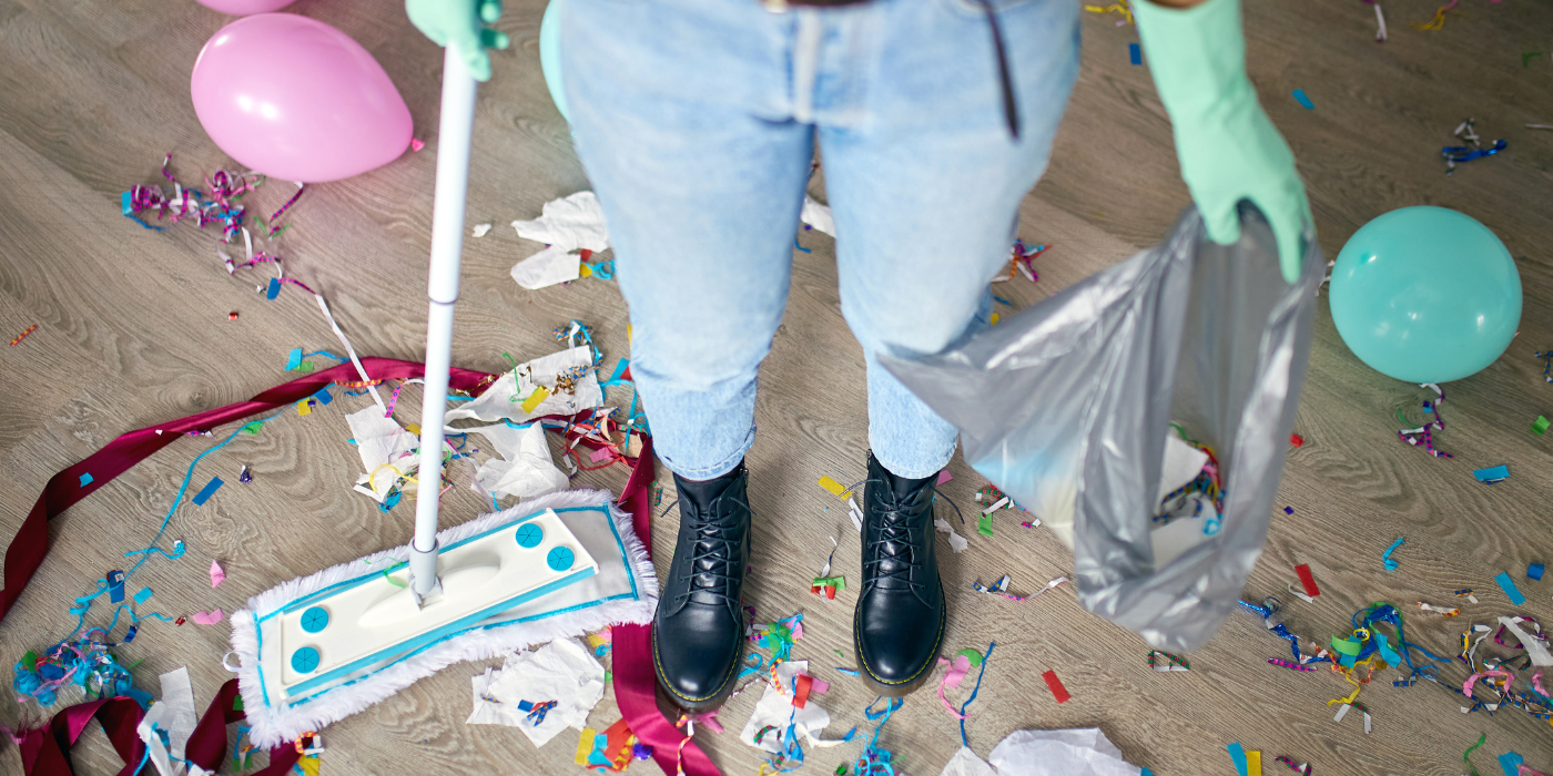 How to Clean Your Home After a Party woman-with-pushbroom-cleaning-mess-of-floor-in-room