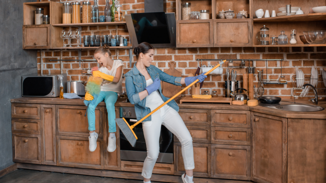 How-to-Organize-Your-Cleaning-Routine-for-Maximum-Efficiency-daughter-singing-and-mother-pretending-playing-on kitchen